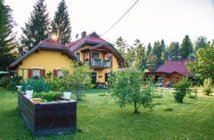 a yellow house with a yard with trees at Ferienhaus Arneitz in Faak am See