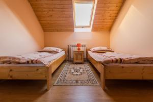 a attic room with two beds and a window at Dolina Orła in Wola Matiaszowa