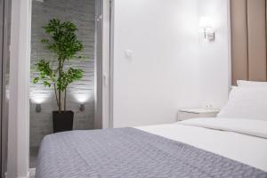 een slaapkamer met een bed en een potplant bij Veria Luxury Suite in Veria