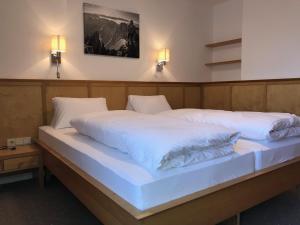 1 Schlafzimmer mit 2 Betten mit weißer Bettwäsche und Beleuchtung in der Unterkunft Apartment Paula in Seefeld in Tirol