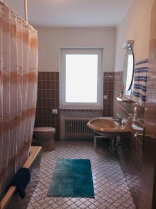 ein Bad mit einem Waschbecken, einem WC und einem Fenster in der Unterkunft Ferienwohnung Becker in Ellenz-Poltersdorf