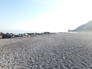 una spiaggia con rocce e l'oceano sullo sfondo di Living Piraino casa vacanze a Piraino