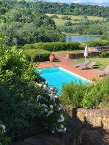 a swimming pool in a garden with a lake at Castellare Di Tonda Tuscany Country Resort & Spa in Montaione