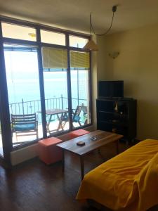 a bedroom with a bed and a table and a balcony at Apartment Kaneo in Ohrid