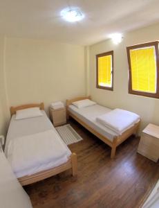 a room with two beds and two windows at Apartment Kaneo in Ohrid