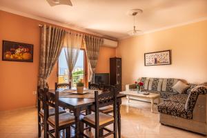 a living room with a table and a couch at Great Alexander Suites in Sarandë