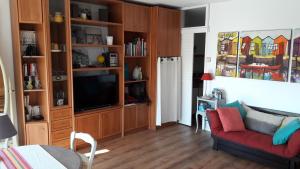 sala de estar con sofá rojo y TV en Studio joigny Pereire, en Arcachon