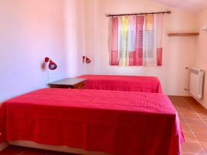 two beds in a room with red sheets at Casa na Comporta in Comporta