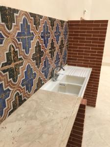 a bathroom with a sink and a tile wall at Dimora Tipica in Marsala +134 photos