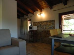 un soggiorno con divano, tavolo e forno a microonde di casa Grinovero a Cividale del Friuli