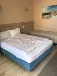 ブワディスワボボにあるPokoje i apartamenty "Iza"のベッド(白いシーツ、枕付)