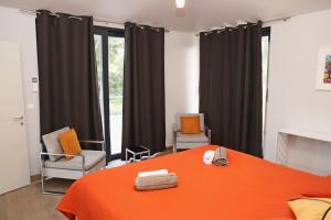 sypialnia z pomarańczowym łóżkiem i 2 krzesłami w obiekcie Seaside villa at Prizba w mieście Prižba +21 zdjęć