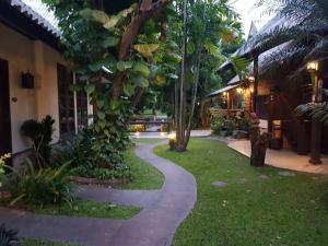 a walkway in front of a house with trees at Rimtarn Resort in Mae Hong Son +27 photos