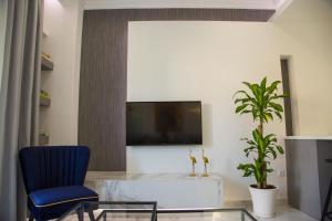 a living room with a blue chair and a tv at Veria Luxury Suite in Veria