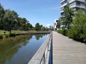 a bridge over a river next to a building at Bel appartement T2 près du lac avc un parking privé in Bordeaux