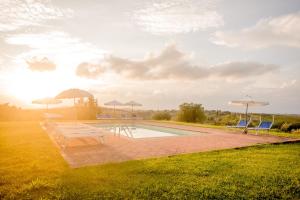 Castellare Di Tonda Tuscany Country Resort & Spa في مونتايون: مسبح مع كراسي ومظلات على عشب