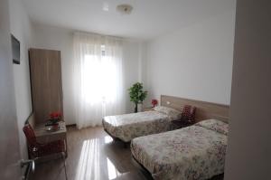 a hotel room with two beds and a window at Residence Piemonte in Sesto San Giovanni