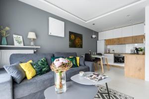 a living room with a couch and a table at M&R Apartament Airport&Business DeLuxe Cybernetyki 17 - underground garage - free WiFi - Netflix - air conditioning - self check-in, close by Chopin Airport in Warsaw
