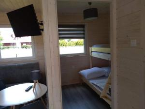 a small room with a bunk bed and a desk at Domki na górce in Kołczewo