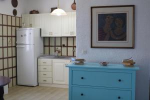 a kitchen with a blue dresser and a refrigerator at Lefkada Beachfront Apartment in Nikiana