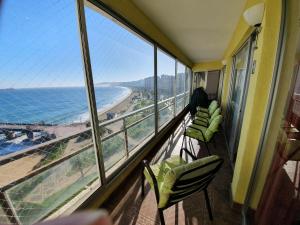 balcón con sillas y vistas a la playa en Hermoso Departamento Frente al Muelle Vergara - Viña del Mar, en Viña del Mar