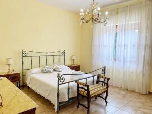 una camera con letto, sedia e lampadario a braccio di Giardino Marino a Marsala