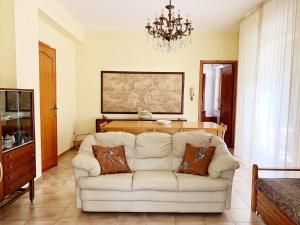 un soggiorno con divano bianco e lampadario pendente di Giardino Marino a Marsala