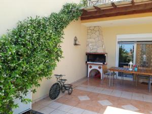 a bike parked next to a house with a fireplace at Villa Potidea Panorama in Nea Potidaea