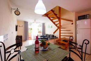 una cucina e un soggiorno con tavolo e bottiglia di vino di Apartamentos El Cortijo a Playa de las Americas