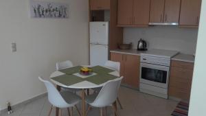 a kitchen with a table and chairs and a refrigerator at STERNES house in Agios Leon