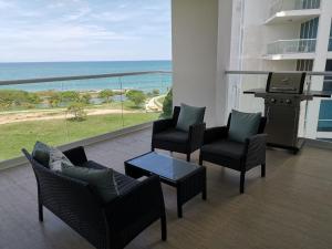 d'un balcon avec des chaises et une table offrant une vue sur l'océan. dans l'établissement Ocean 3, Playa Blanca, à Río Hato