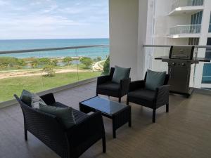 a balcony with chairs and a table and a view of the ocean at Ocean 3, Playa Blanca in Río Hato