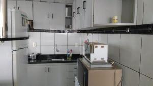 坎皮納的住宿－Apartamento Catolé até 5 pessoas，小厨房配有白色橱柜和微波炉