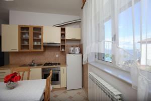 - une cuisine avec un réfrigérateur-congélateur blanc à côté d'une fenêtre dans l'établissement Apartments Sara, à Kali