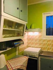 a small kitchen with green cabinets and a stove at Angela Seaside Summer house in Dhílesi