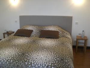 a bed with two pillows on it in a bedroom at Le Dolmen in Primelin