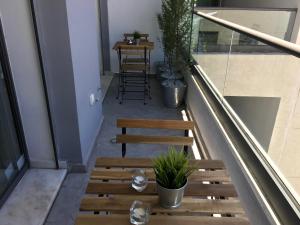 a balcony with three wooden benches and a table at Appartement les pieds dans l'eau WELCOME STAY in Mohammedia