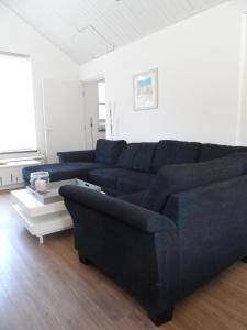 uma sala de estar com um sofá azul e uma mesa em Hoeveheikant Vakantiewoningen em Lage Mierde