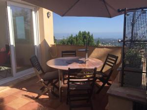 a table and chairs on a balcony with an umbrella at Saberic in Vence