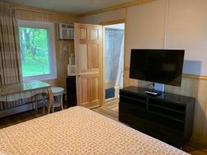 a bedroom with a bed and a flat screen tv at Wisconsin Aire Motel in Random Lake