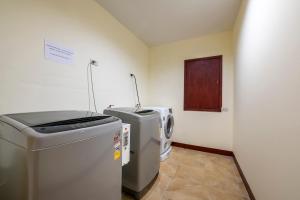 a laundry room with two refrigerators in a room at Scala Hostel in Bangkok