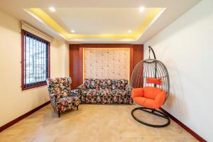 a living room with a chair and a swing at Scala Hostel in Bangkok