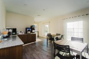 a kitchen and dining room with a table and chairs at Scottish Inn & Suites - Atascocita in Humble