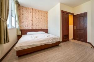 a bedroom with a bed and a wooden door at Scala Hostel in Bangkok
