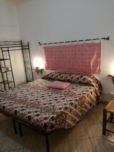 a bedroom with a bed with a colorful bedspread at Zia Amalia Villa Asfodelo in Alghero