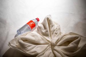 a bottle of alcohol sitting on top of a towel at Scala Hostel in Bangkok