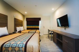 Tempat tidur dalam kamar di Scottish Inn & Suites - Atascocita