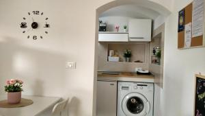 a laundry room with a washing machine and a clock at CasaDiPaola in Chieti