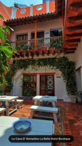 a building with tables and a balcony with plants at Casa D´Remedios La Bella Hotel Boutique in Ciénaga