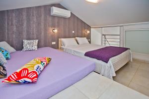 dwa łóżka w pokoju fioletowo-białym w obiekcie Island Hvar Seaside Villa Levanda with Beach, Pool & Seaview w Hvarze +37 zdjęć